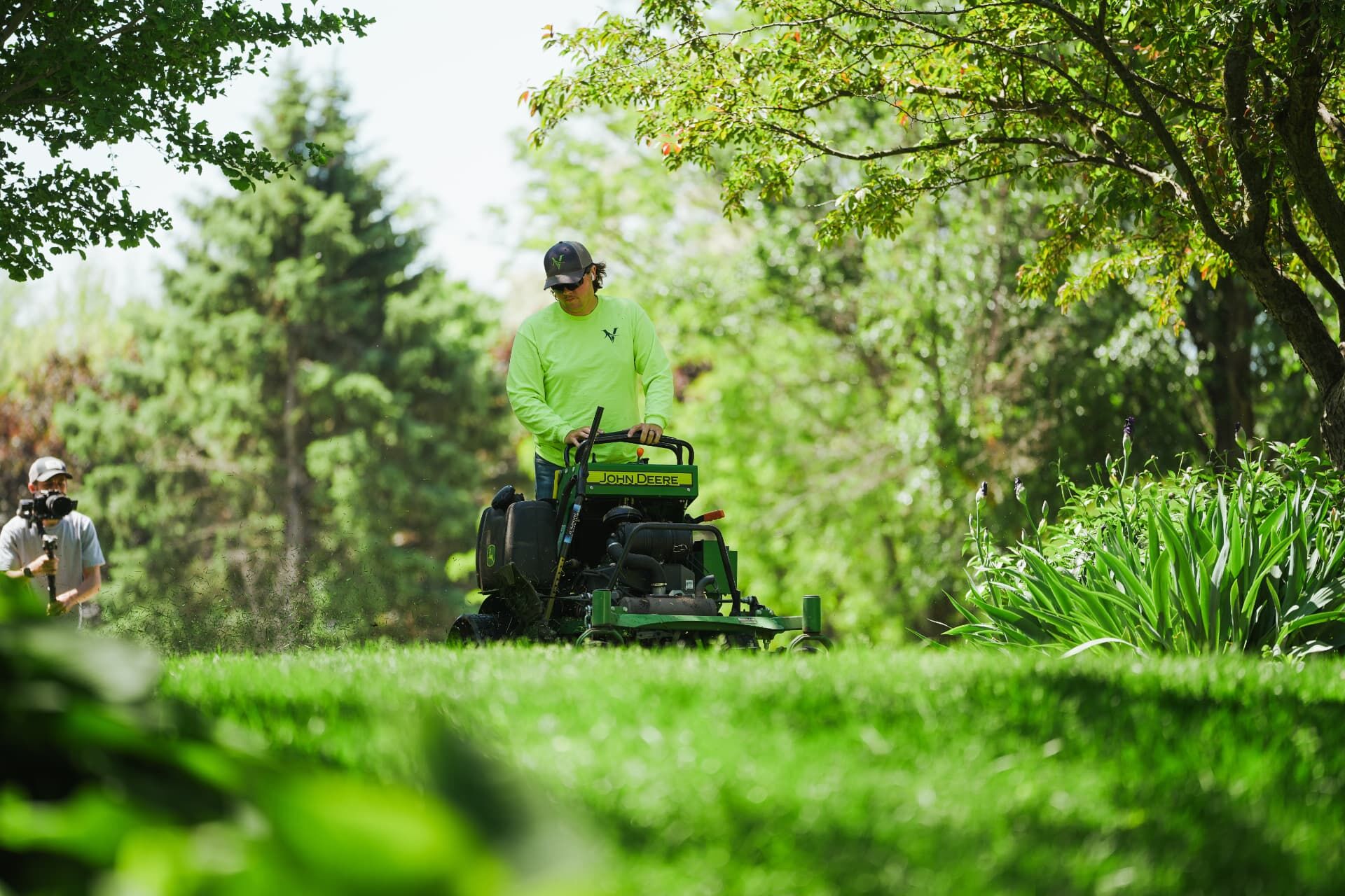 HCA videographer filming a landscaper mowing for a client video ad